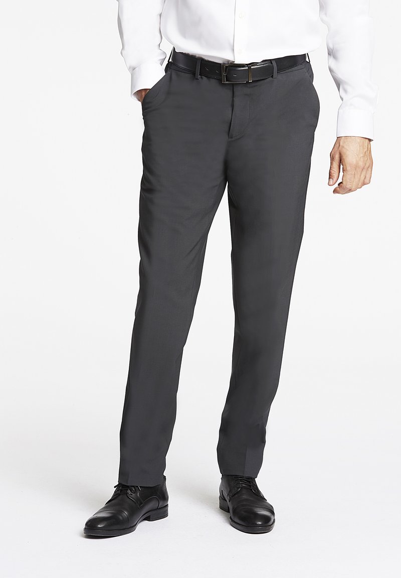 Pantaloni formali grigi realizzati in tessuto liscio, caratterizzati da una vestibilità slim, due tasche laterali e abbinati a scarpe eleganti nere.