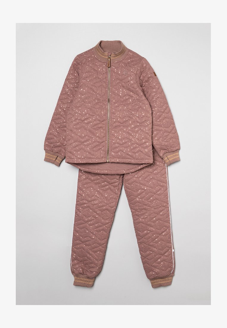 Gequilte twee-delige set in stofroze met een geometrisch patroon. Beschikt over een zip-up jack en bijpassende broeken met geribbelde manchetten en witte zijstrepen.