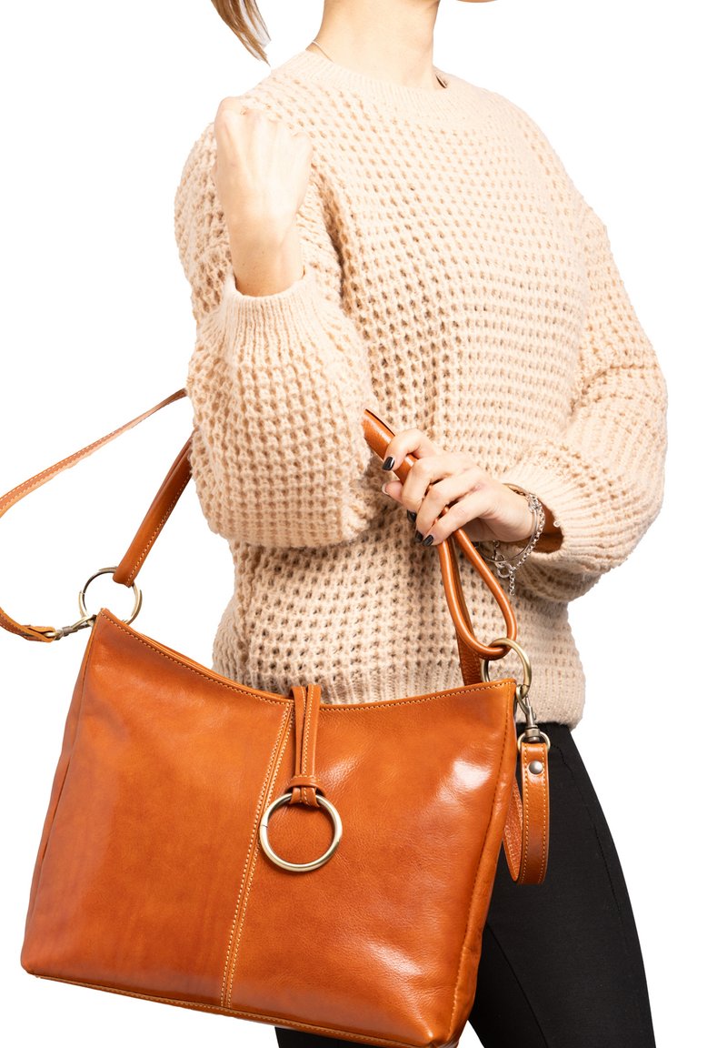 Borsa a mano in pelle marrone chiaro con forma rettangolare, texture lucida, grande anello decorativo sul davanti e tracolla regolabile.