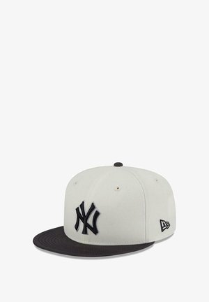 Gorra de béisbol blanca y negra con el logo de los New York Yankees bordado en la parte frontal y el logo de New Era en el lateral.