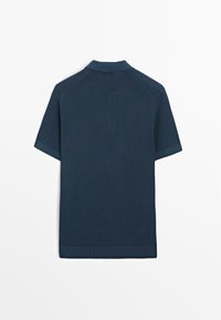 Polo shirt corto in un blu navy scuro realizzato in tessuto a maglia testurizzato, caratterizzato da un colletto classico e orlo a coste. Vista posteriore con design senza cuciture.