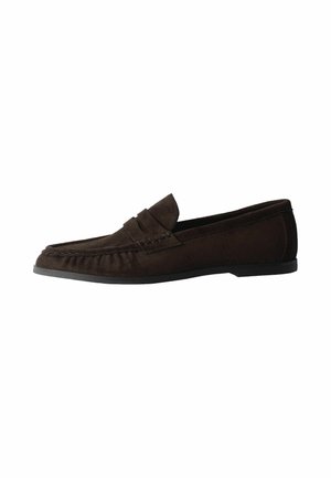 Dark brown suede slip-on loafer with a low black sole and decorative strap across the top, shown from the side.