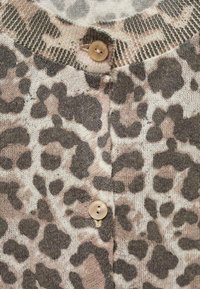 Leopardikuosi neulecardigan pehmeästä kankaasta, jossa on pyöreä kaula-aukko, nappisuljenta ja hienovarainen tekstuurikuvio beigeissä ja ruskeissa sävyissä.