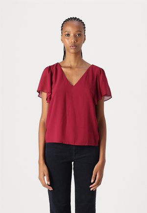 Maroon blouse with short, ruffled sleeves and a V-neck design. Lightweight, smooth texture, paired with black fitted pants.