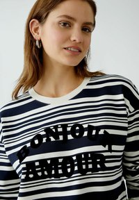 Marineblauwe en witte gestreepte sweatshirt met een ronde halslijn, voorzien van zwarte fluwelen letters "BONJOUR AMOUR" over de borst.