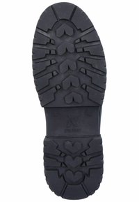 Black rubber shoe sole with textured surface, featuring a zigzag tread pattern and prominent heart-shaped designs at the center.