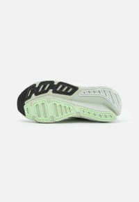 Suola di scarpe da corsa caratterizzata da un design multi-strato in verde chiaro e nero. Gomma testurizzata con motivi intagliati per aderenza e flessibilità.