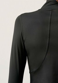 Svart långärmad topp med hög krage, som har ett mjukt, stretchigt tyg och en sömdetalj på baksidan. Elegant, figurnära silhuett.