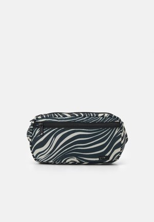 Pochette zippée rayée noire et blanche façon zèbre avec une poche avant et une petite étiquette logo sur un fond uni.