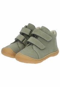 Scarpe in pelle verde chiaro con due cinturini in velcro, forma arrotondata e suole in gomma beige. Texture morbida e cuciture visibili.