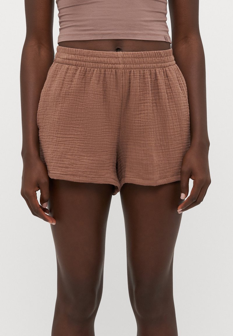 Shorts bruns texturés avec un waistband élastique et une coupe ample. Présente un tissu froissé pour plus de dimension et de confort.