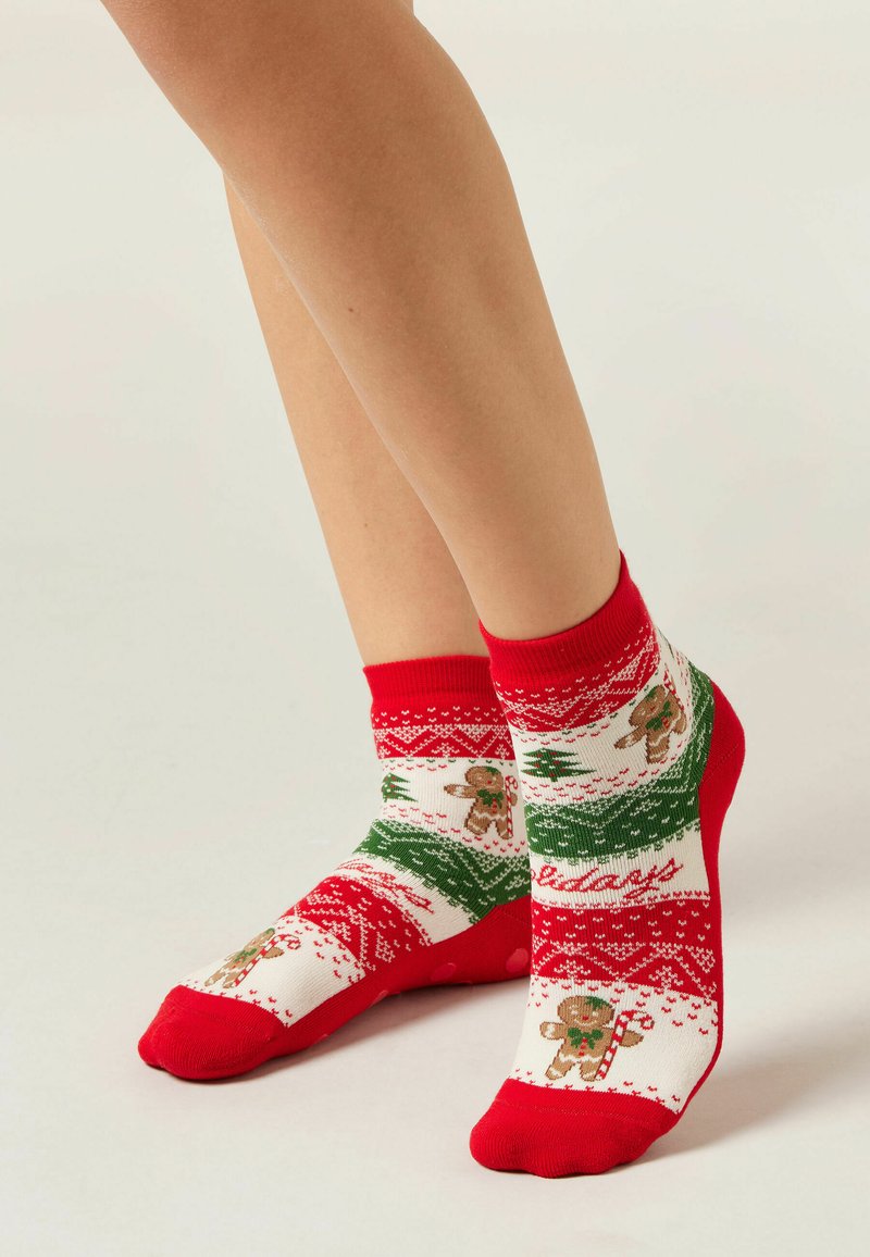 Červeno-bílé ponožky do kotníků s motivem perníčků, zelenými akcenty a texturovaným pleteným designem s vánočními motivy.