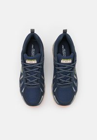 Marina löparskor med nätovandel, reflekterande detaljer och innersula av minnesskum. Utrustade med ett mönstrat snörningsdesign och en flerfärgad sula.