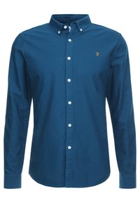Niebieska koszula z długim rękawem, wykonana z bawełny, z kołnierzykiem zapinanym na guziki, białymi guzikami i małym haftowanym logo na piersi.