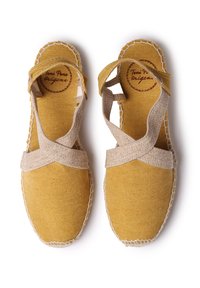 Žluté espadrilky z látky s křížovým vzorem v béžové barvě, texturovaný povrch a kontrastní bílý šev kolem podešve.