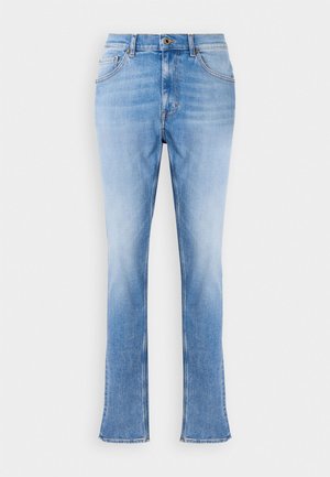 Jeans de denim azul claro com um corte reto e pernas ligeiramente largas. Apresentam design clássico de cinco bolsos e fecho com botão de latão.