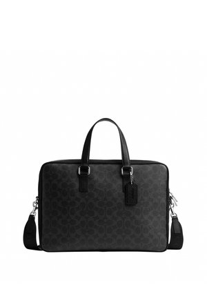 Sacoche en cuir noir avec double poignée, bandoulière amovible, texture subtilement dessinée et étiquette en cuir suspendue.