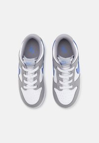 Scarpe sportive bianche e grigie con accenti blu, dotate di una tomaia liscia, punta perforata e lacci piatti. Logo Nike sulla linguetta.