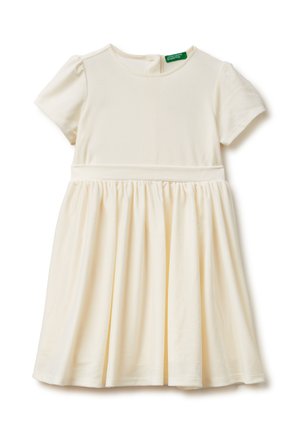 Mädchenkleid in Creme mit kurzen Ärmeln, tailliertem Bund und Rock, rundem Ausschnitt und einem kleinen grünen Markenetikett innen am Kragen.