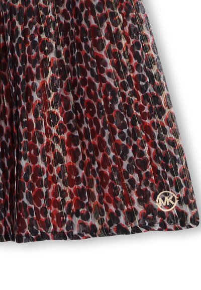 Jupe plissée en tissu léger avec un motif léopard rouge et noir, ornée de accents dorés et d'un logo au bas.