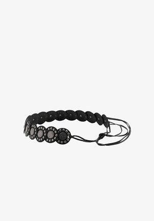 Cintura nera con dischi metallici rotondi chiodati collegati insieme e cinturini in pelle regolabili su sfondo bianco.