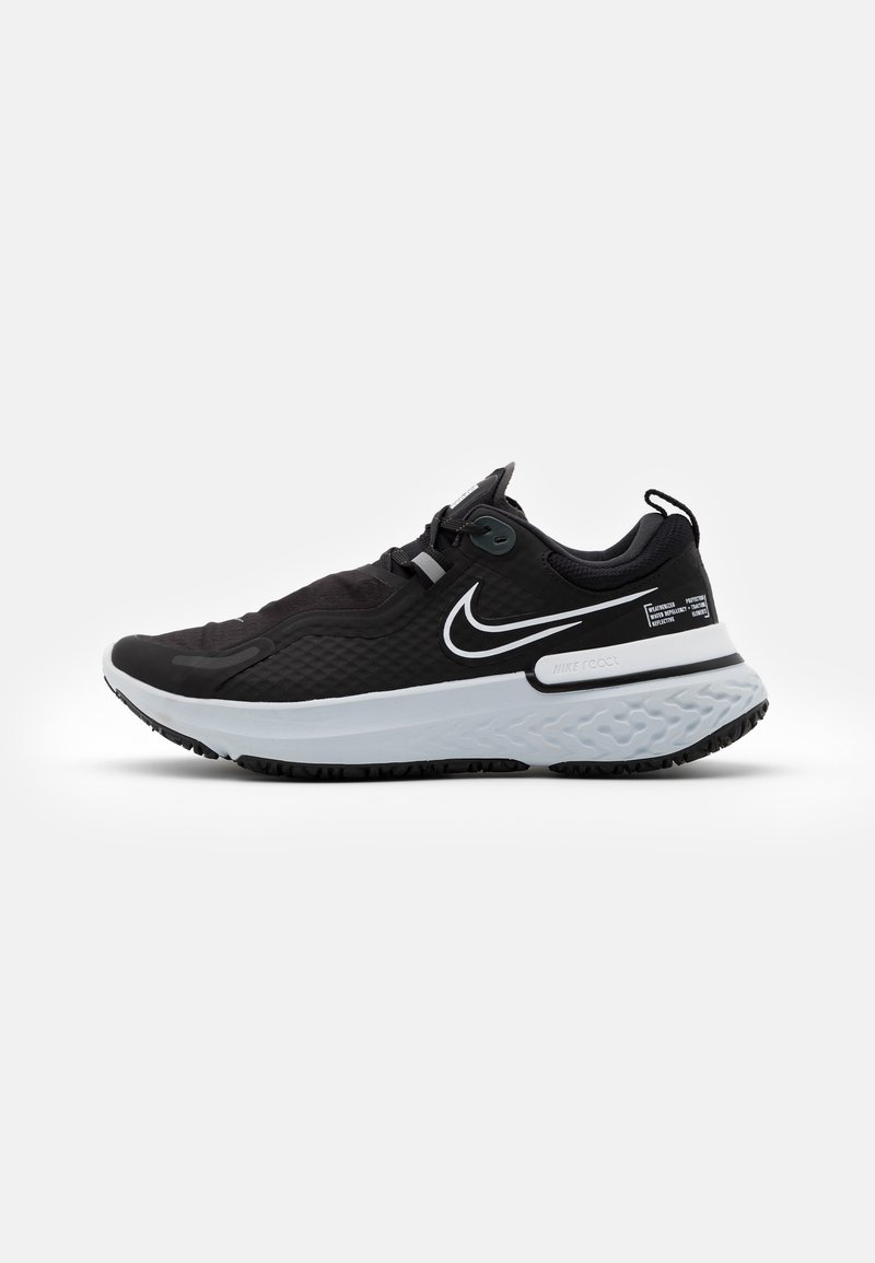 Chaussure de running Nike en noir et blanc avec semelle texturée, logo swoosh Nike et lacets attachés sur un fond blanc uni.