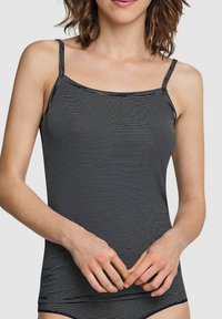 Navy and white striped tank top with thin straps. Smooth fabric, fitted design, featuring a straight neckline and simple, clean lines.