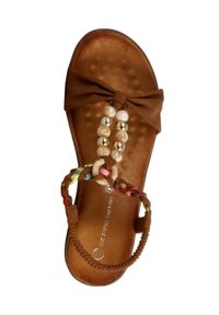 Sandale plate marron avec un nœud en avant, des accents de perles et de perles métalliques, et une sangle tressée multicolore.