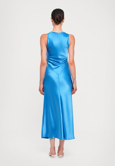 Blauwe satijnen jurk met een mouwloos ontwerp, een zachte textuur en een vloeiende silhouette die tot halverwege de kuit valt. Draperingen aan de achterkant.