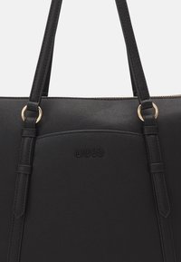 Borsa a spalla nera strutturata realizzata in materiale testurizzato. Presenta finiture in metallo dorato e il logo "LIU-JO" in rilievo sul davanti.
