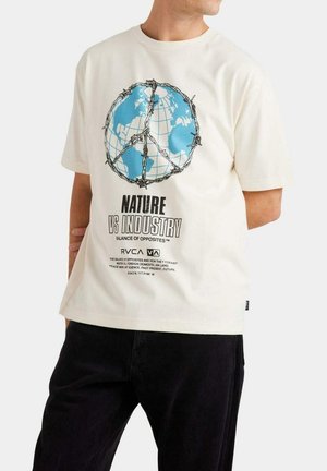 Camiseta color crema con un gráfico de un globo terráqueo, continentes azules y alambre de espino. El texto debajo dice "NATURALEZA VS INDUSTRIA" en letras negritas negras.