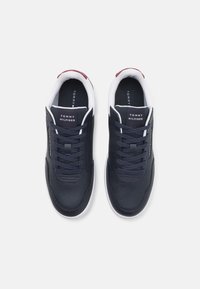 Mörkblå lädersneakers med vita sulor, rund tå och snörning. Har Tommy Hilfiger-märke och perforerade detaljer.
