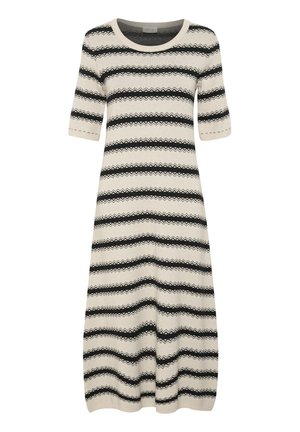 Šviesiai kreminis megztinis su trumpomis rankovėmis, kuriame yra horizontalios juodos zigzago juostos. Apvalus iškirpimas ir laisvas siluetas.