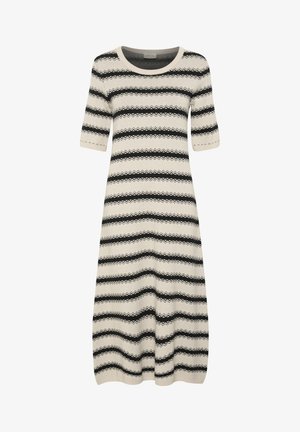 Robe en tricot à manches courtes de couleur crème clair, avec des rayures noires en zigzag horizontales. Encolure ronde et coupe décontractée.