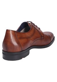Scarpe eleganti in pelle marrone con finitura liscia, punta arrotondata e design con lacci. Presentano una suola in gomma nera e dettagli di cucitura discreti.