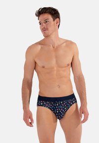 Marineblaue Herrenunterwäsche in Form eines Slips mit buntem tropischem Muster; weicher Stoff, elastischer Bund, minimales Designs für Abdeckung.