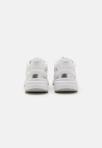 Sneakers bianchi con tomaia in pelle liscia, dettagli in argento, colletto imbottito e suola testurizzata. Presentano una linguetta sul tallone per indossarli facilmente.