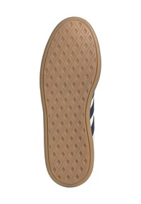 Shoe sole with a patterned rubber base in tan, featuring a diamond texture for grip, complemented by dark blue and white stripes on the side.