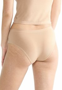 Beige Baumwoll-Hipster-Unterwäsche mit glatter Textur, ausgestattet mit einem breiten elastischen Taillenbund und einem minimalen Schnittdesign.