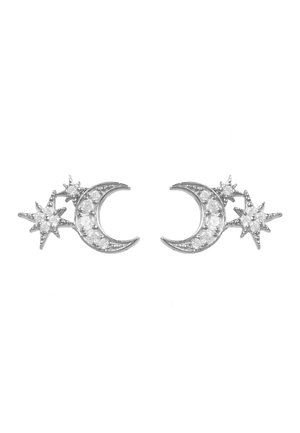 Paire de boucles d'oreilles en argent en forme de croissants de lune avec des motifs d'étoiles, décorées de petites pierres précieuses transparentes, sur fond blanc.