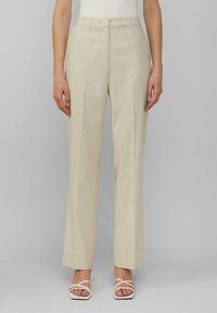 Beige linnen broek met een rechte pasvorm, subtiele textuur en voorvouwen. Gesloten met een enkele knop aan de taille.