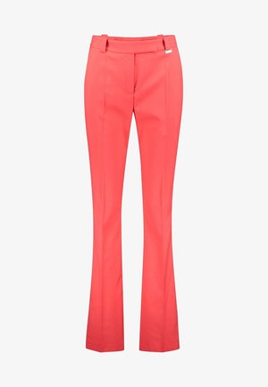 Pantalon rose corail sur mesure avec taille haute, passants de ceinture, plis à l’avant et jambes évasées.