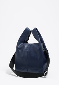 Námorná kožená taška s jemným, textúrovaným povrchom, s jedinečným prehnutým vrchom a čiernym nastaviteľným popruhom. Zipsové uzatvorenie so striebornými komponentmi.