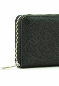 Portafoglio in pelle nera con superficie testurizzata, chiusura a zip, hardware della zip in argento e forma rettangolare slanciata.
