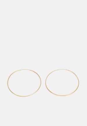 Pendientes de aro de oro con un diseño suave y redondeado. Cada aro es delgado y ligero, sin adornos ni patrones.