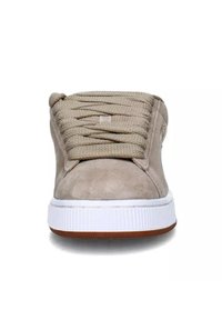 Sneakers con tomaia in suede beige, lacci piatti beige, suola in gomma bianca e dettaglio marrone sulla parte inferiore. Punta arrotondata e colletto imbottito.