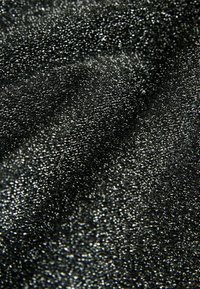 Czarna teksturowana tkanina o metalicznym połysku, z drobną, wypukłą powierzchnią, która różnie odbija światło wzdłuż swoich fałd.