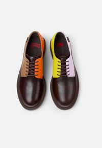 Scarpe in pelle marrone con accenti arancioni, gialli e lavanda sul davanti, dotate di lacci marroni e design della punta arrotondata.