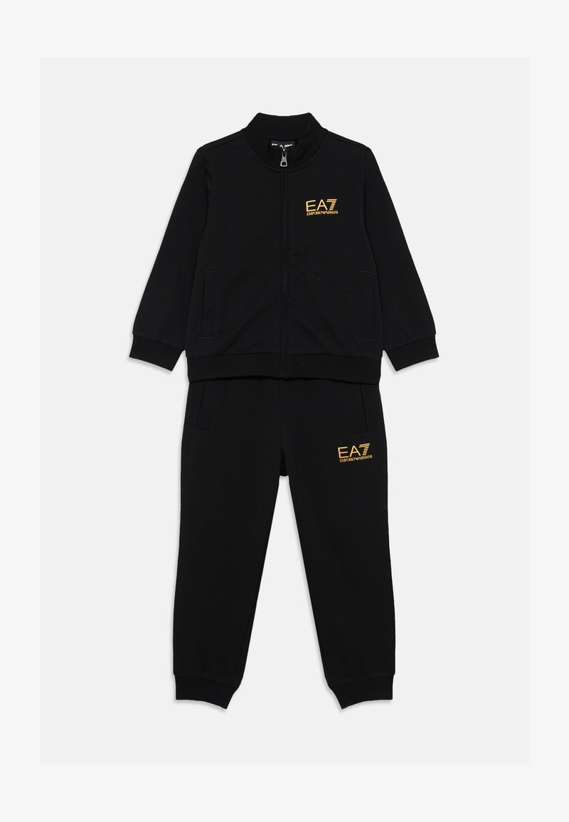 Conjunto de chándal negro que incluye una chaqueta con cremallera y pantalones a juego, confeccionado en una tela suave con acentos del logo dorado de EA7 en ambas piezas.