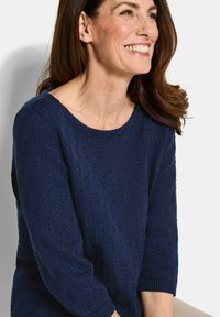 Marineblauer gestrickter Pullover mit strukturiertem Muster, Rundhalsausschnitt und Dreiviertelärmeln. Weicher Stoff mit gerippten Bündchen und Saum.